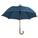 Dieser Holzregenschirm ist mit einem Reflektorband ausgestattet und zusätzlich individuell bedruckbar.